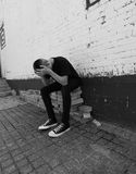depressed-teen-boy-black-white-teenage-sits-against-brick-building-head-hands-room-text-76157980